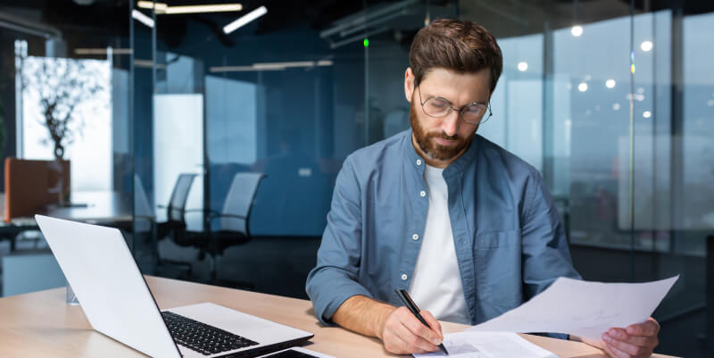 A bookkeeper is working on a laptop